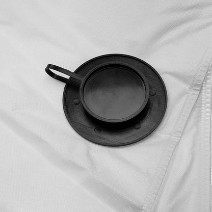 A close-up shot of the black rubber inlet on a white vacuum filter bag, now closed and sealed with its attached circular cap.