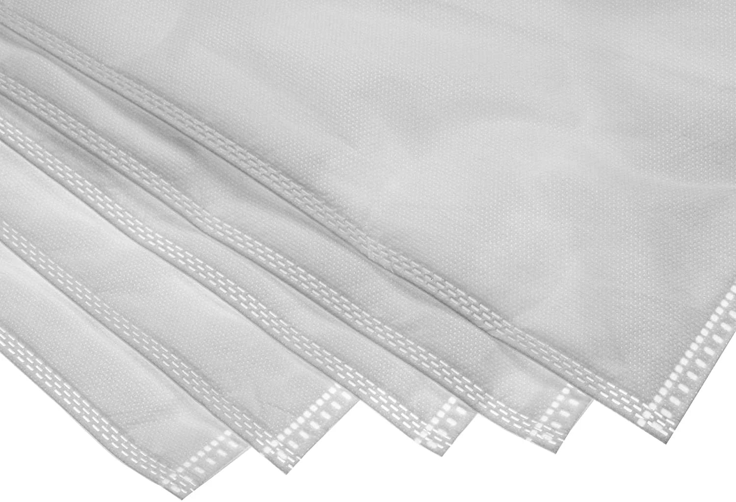 A close-up shot of the reinforced, double-stitched edges of stacked white vacuum filter bags.