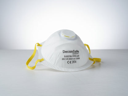 A white DeconSafe Solutions FFP2 protective respirator mask with a yellow strap and a breathing valve.