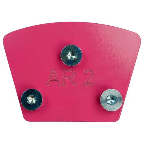 A pink, fan-shaped metal plate for a concrete floor grinder, engraved with "AR 2" and featuring three installed mounting bolts.